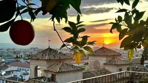 A balcony with a view of a cityscape during sunset, featuring traditional buildings and a clear sky. - Carmen de Belén, tranquility next to the Alhambra (Granada)