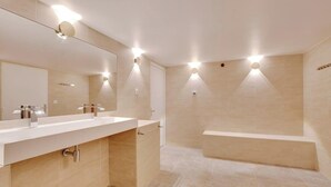 Une salle de bain moderne avec un double vasque, un grand miroir et un éclairage encastré.