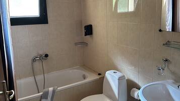 A bathroom with a bathtub, toilet, and sink.