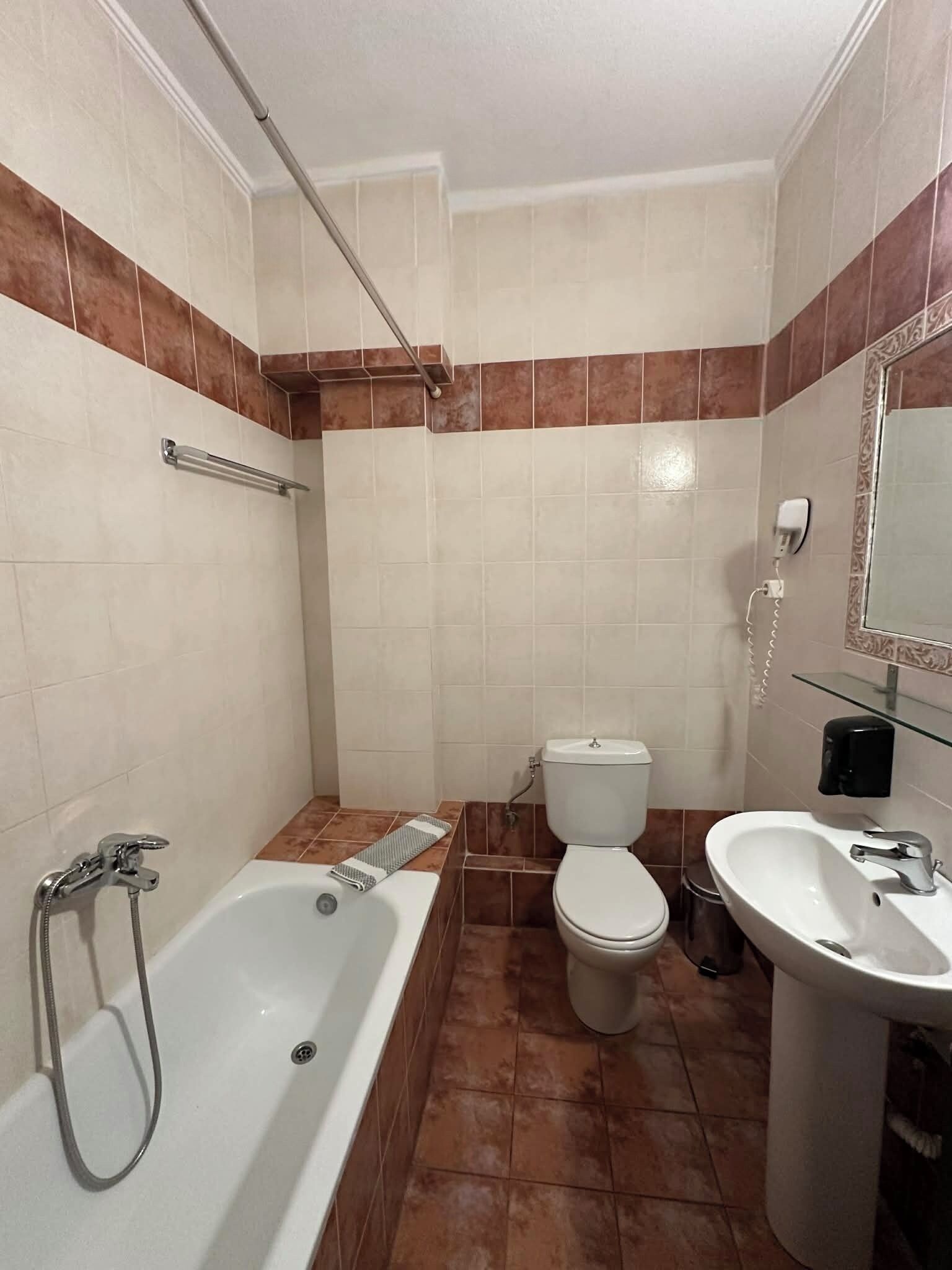 A bathroom with a bathtub, toilet, and sink.