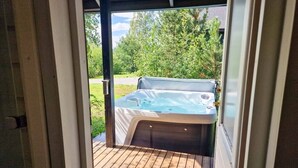 A hot tub on a wooden deck with a view of a green landscape. - Villa Rantatuuli, Himosranta (Keski-Suomi)