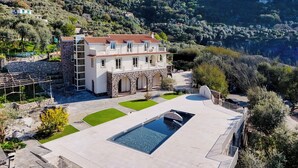 A large villa with a swimming pool, surrounded by lush greenery and hills. - Villa Gialisa (Sorrento)