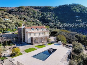 A large villa with a swimming pool, surrounded by lush greenery and hills. - Villa Gialisa (Sorrento)