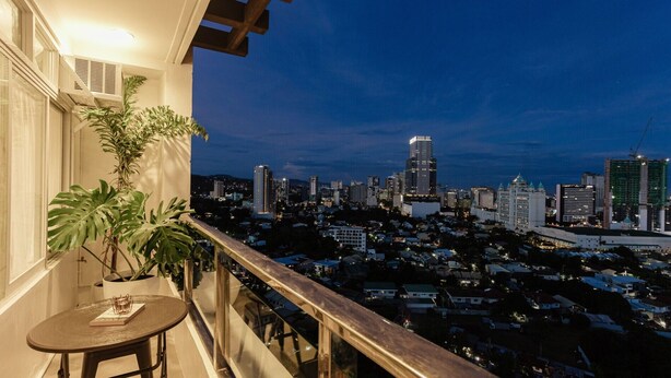 A balcony with a view of a city skyline at dusk.