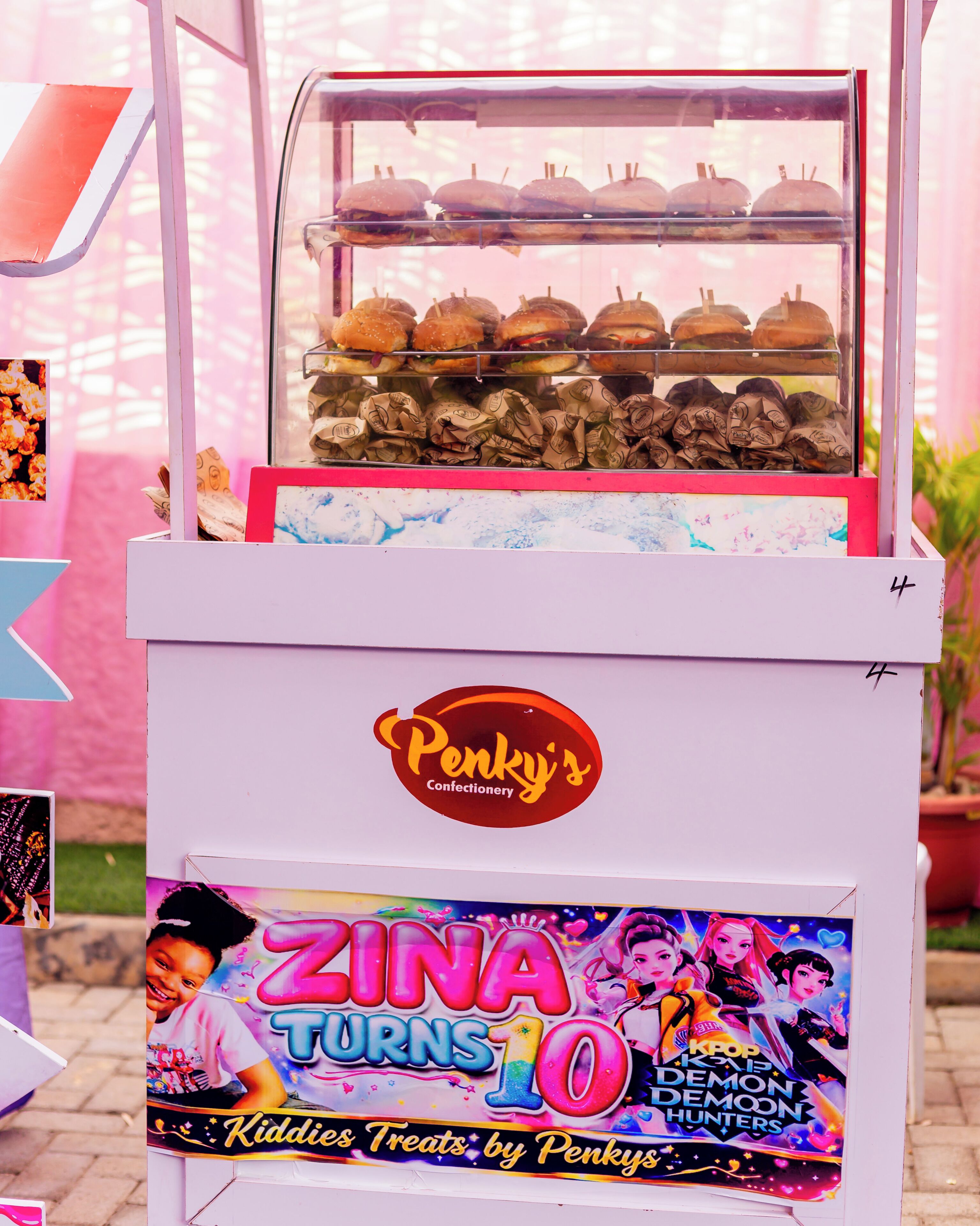 A vending machine with a sign reading 'ZINA TURNS 10' and 'KIDDIES TREATS by Penky's.'