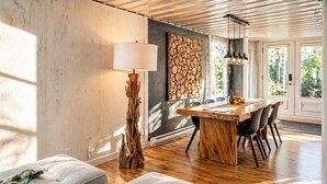 A dining area with a wooden table, chairs, a lamp, and a wall art piece. - Charming Retreat in Eastman | Spa, Bike & Hike ! (Eastman)