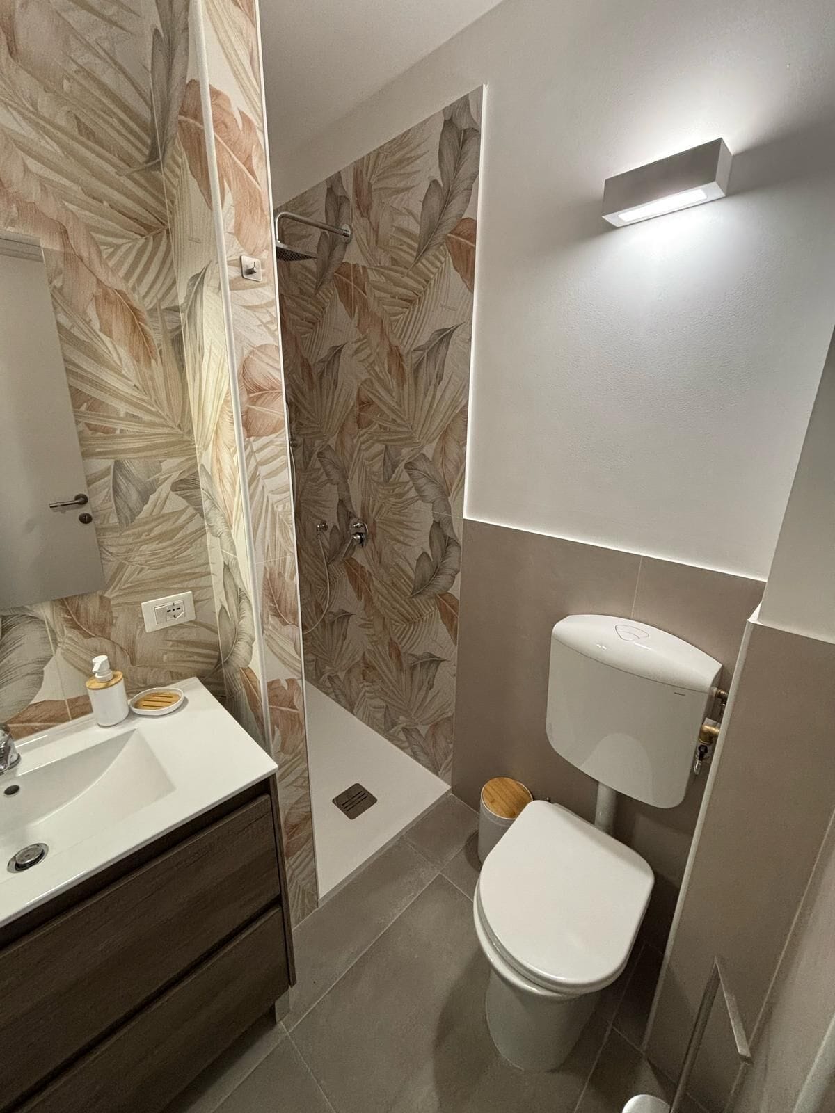 A bathroom with a shower, toilet, and sink.