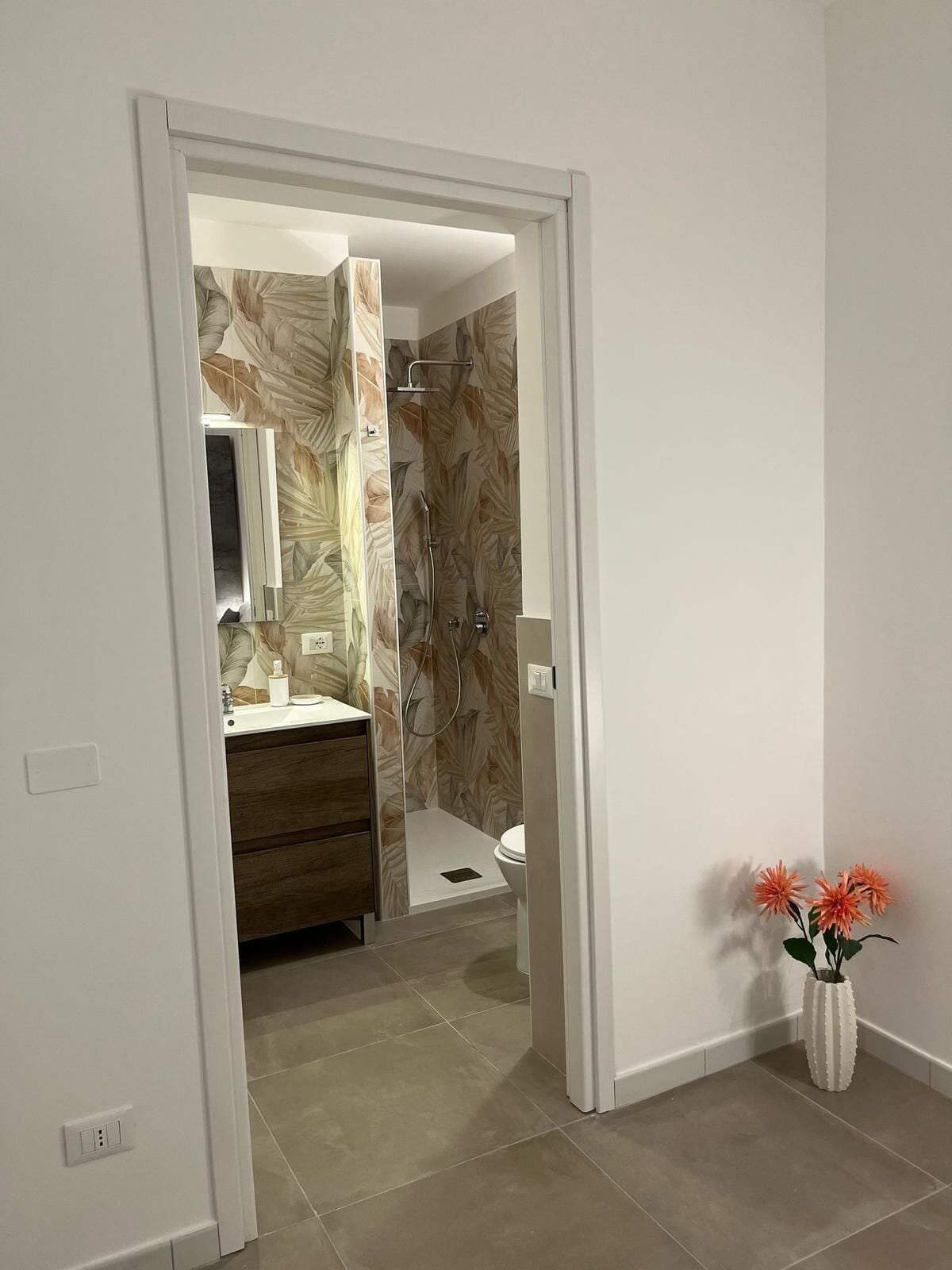 A modern bathroom with a shower, toilet, and vanity.