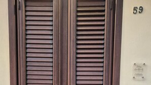 Une porte en bois à deux battants, avec une plaque portant le numéro « 59 » et une petite plaque au-dessus.