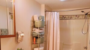 A bathroom with a sink, toilet, and shower. There is a towel rack with folded towels and a shelf with toiletries. - "Holland Hills" offers a clean, quiet, comfortable stay. Paved access. Nice area (Franklin)