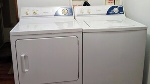 A front-loading washer and dryer unit with control panels, a wooden plaque above, and a shelf with cleaning products. - "Holland Hills" offers a clean, quiet, comfortable stay. Paved access. Nice area (Franklin)