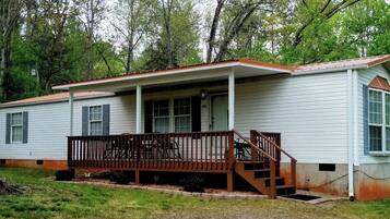 A single-story mobile home with a porch and a small staircase leading to the entrance.
