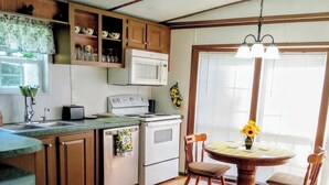 A kitchen with wooden cabinets, a white stove, and a dining table with chairs. - "Holland Hills" offers a clean, quiet, comfortable stay. Paved access. Nice area (Franklin)