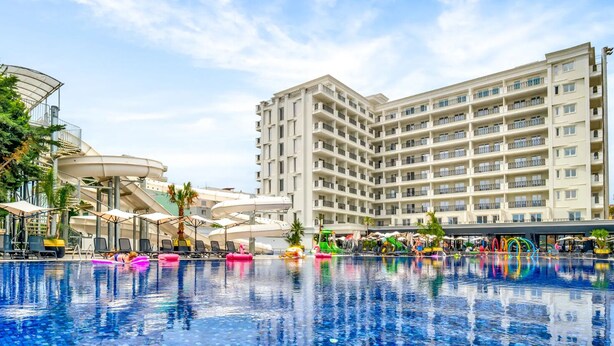 A hotel with a large swimming pool, outdoor seating, and a water slide. - Bonita Luxury Resort & Spa (Golem)
