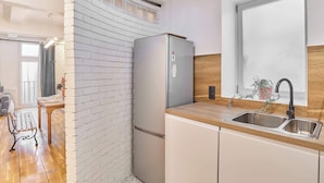 A modern kitchen with a built-in refrigerator, a wooden countertop, and a stainless steel sink. - Magnificent flat in Saint Germain des Près (Paris)
