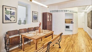 A dining area with a wooden table set for four, benches, and a cabinet. - Magnificent flat in Saint Germain des Près (Paris)