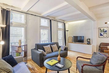 Salon avec table basse, TV et espace repas