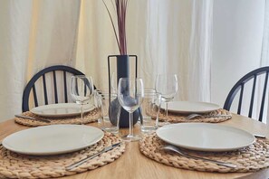 A dining table set with plates, cutlery, and wine glasses, surrounded by woven placemats and chairs. - Sublim & NEW apartement St Germain/Notre Dame (Paris)