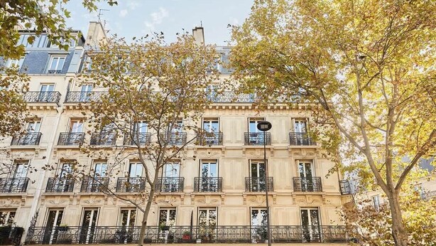 A multi-story building with balconies, large windows, and a tree in the foreground. - Sublim & NEW apartement St Germain/Notre Dame (Paris)