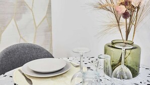 A dining table set with plates, cutlery, and a vase with dried flowers. - New apartment Centre de Paris Bourse (Paris)