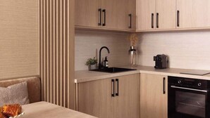 A modern kitchen with wooden cabinets, a black sink, and a built-in oven.