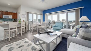 Ein modernes Wohnzimmer mit Blick, einer Essecke und einer Küche.