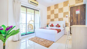 A hotel room with a bed, a window with curtains, a ceiling fan, and a wall with a checkered pattern.
