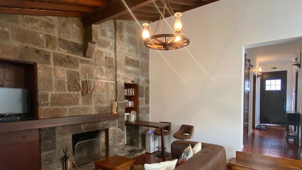 A cozy living room with a stone fireplace, a leather sofa, and a wooden coffee table.