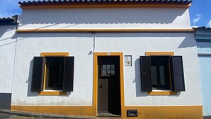 A two-story building with a white facade and yellow trim.