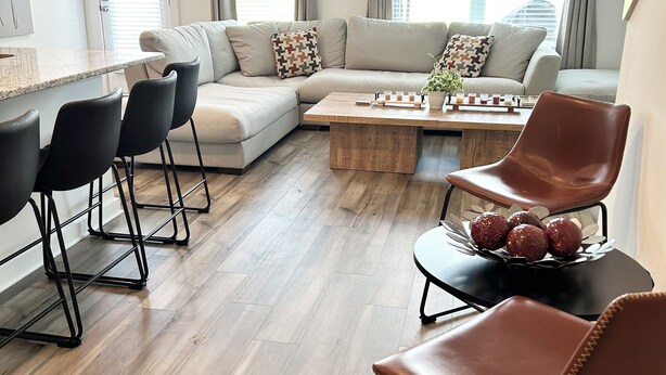 Una sala de estar moderna con un sofá modular, una mesa de centro y un comedor con sillas.