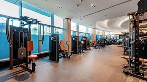 Ein modernes Fitnessstudio mit unterschiedlichen Trainingsgeräten, großen Fenstern und einer großzügigen Gestaltung.