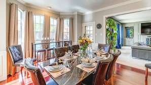 Un comedor con una mesa de mármol, sillas de cuero y un jarrón de flores.
