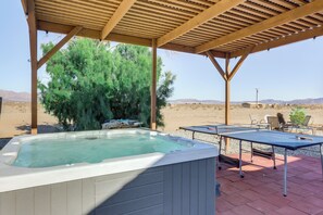 A hot tub under a wooden pergola with a table tennis table nearby. - Hiker's Paradise: Twentynine Palms Home w/ Deck! (Twentynine Palms)