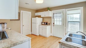 A kitchen with white cabinets, a refrigerator, a microwave, and a sink. - 2 Mi to Dtwn: Studio Suite in Sheboygan (Sheboygan)