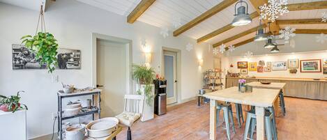 A spacious kitchen with wooden beams, a dining area, and a refrigerator.