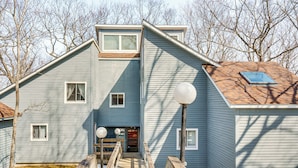 A two-story house with a front porch, a small deck, and a garage. - Mountain Resort Condo With King Bed Suite (Campton)
