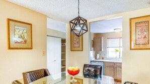 A dining area with a glass table, leather chairs, and a decorative centerpiece.