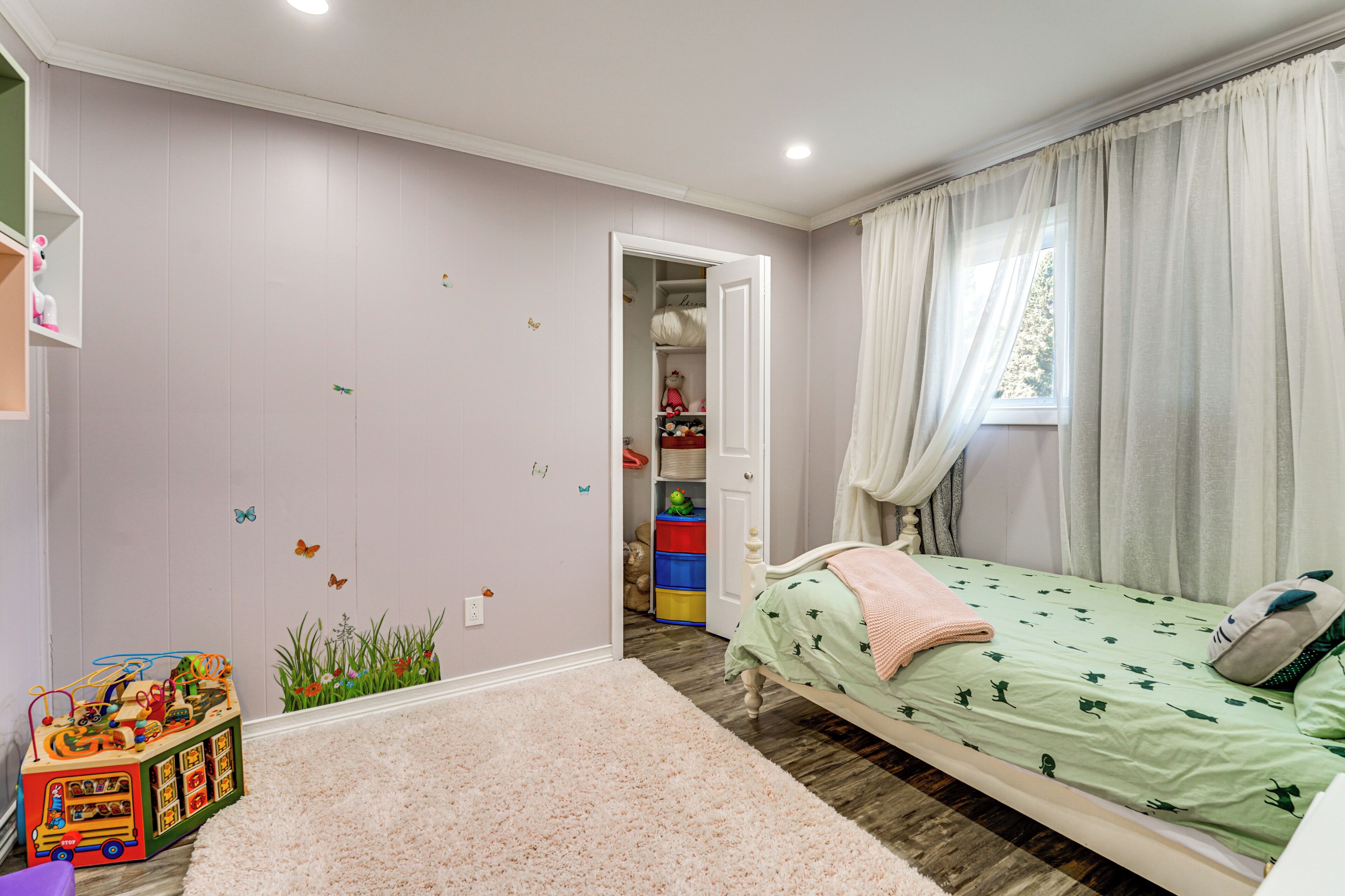 Une chambre d’enfant avec un lit, des jouets et un placard.