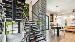 Un intérieur moderne comprenant un escalier, un coin repas et un salon.