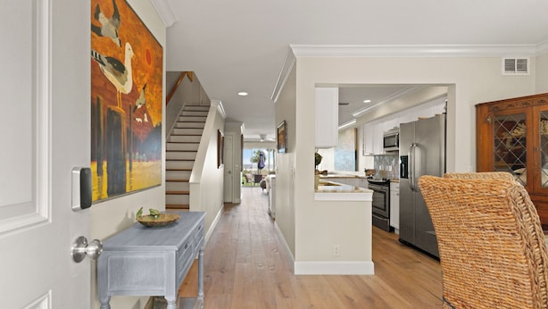 A hallway with a staircase, a dining area, and a kitchen with modern appliances. - Unbeatable location with Ocean Views, sleeps 6 (St Simons Island)