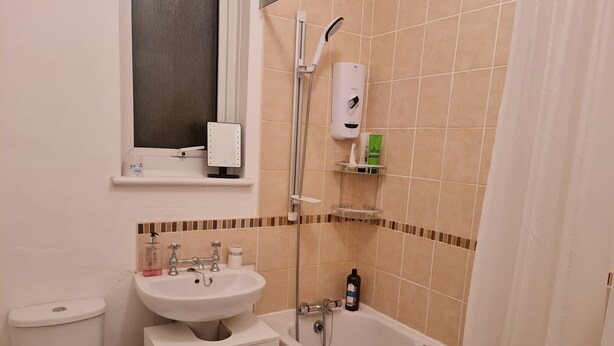 Kombinasi shower/bathtub, pengering rambut, sandal, dan handuk