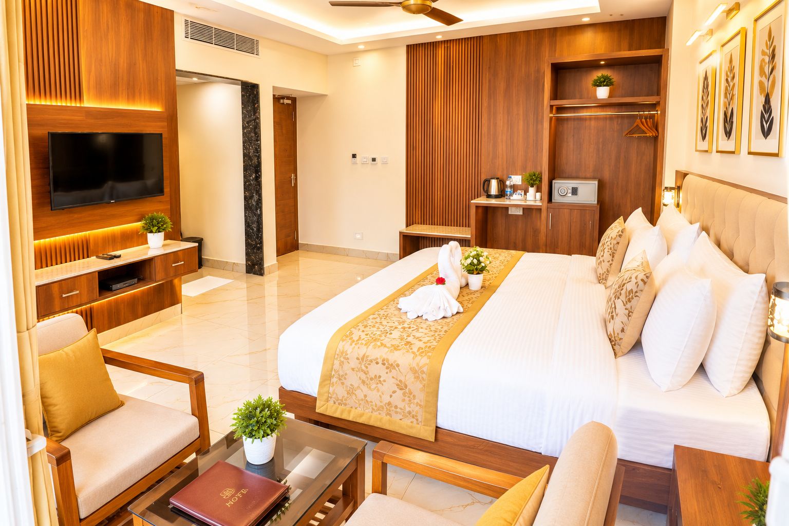 A hotel room with a large bed, a TV, a seating area with a coffee table, and a small kitchenette.