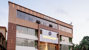 A multi-story hotel with a modern design, featuring a prominent sign for 'The Pearl Shine'.
