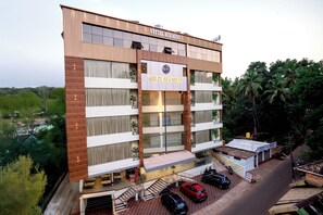 A multi-story hotel with a prominent sign reading "The Pearl Shise." It features a modern architectural design with a mix of glass and wood panels. - HOTEL THE PEARL SHINE (Gokarna)