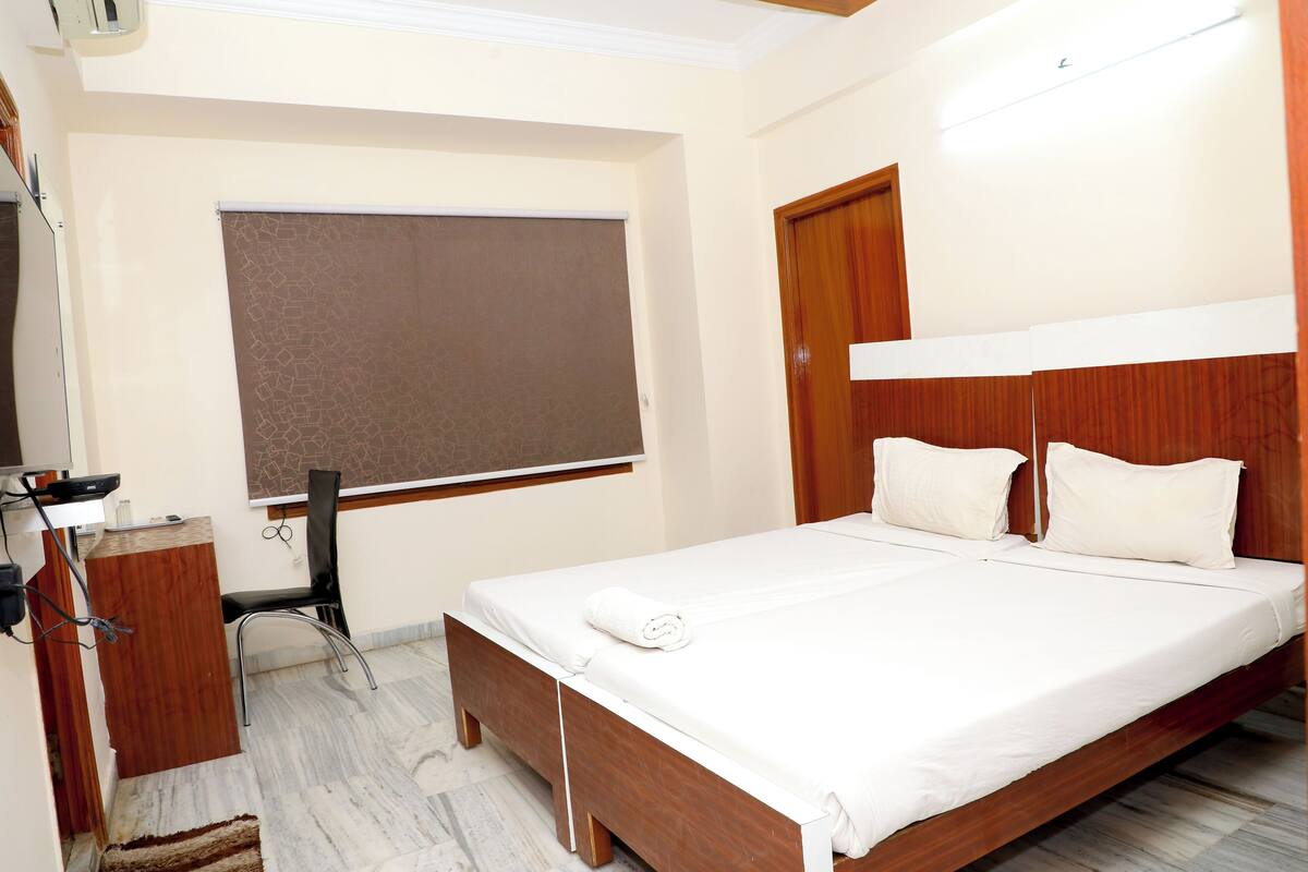 A neatly arranged bedroom with a wooden bed, a desk, and a chair.
