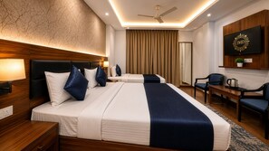 A hotel room with two beds, a desk, a chair, a coffee maker, and a TV mounted on the wall. - Hotel Paradise International by JMD Group (New Delhi)