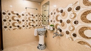 A bathroom with a sink, mirror, and decorative wall tiles. - Hotel Paradise International by JMD Group (New Delhi)