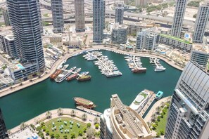 A marina surrounded by high-rise buildings, with boats docked and a clear view of the water.