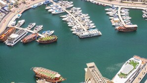 A marina with various boats docked, including yachts and a large cruise ship.