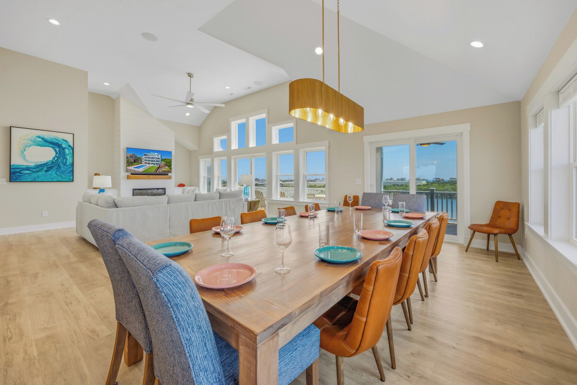 A spacious dining area with a long wooden table, multiple chairs, and a view of the outdoors through large windows.